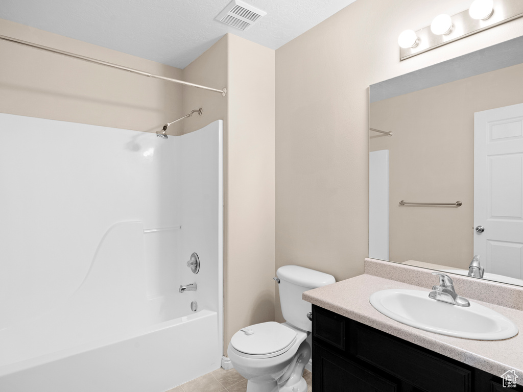 Full bathroom featuring tile patterned flooring, vanity, toilet, and washtub / shower combination