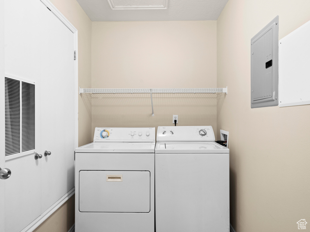 Washroom featuring electric panel and separate washer and dryer