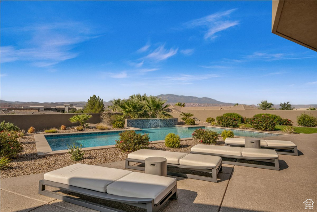 View of swimming pool with pool water feature, a mountain view, and a patio