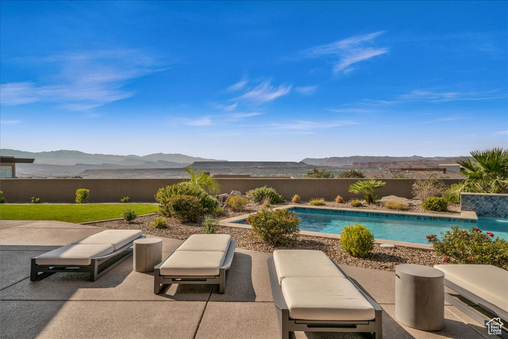 View of patio featuring a fenced in pool and a mountain view