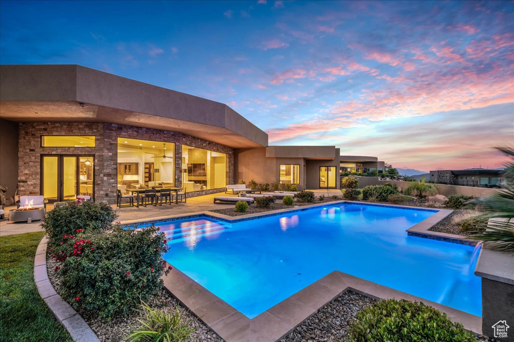 Pool at dusk with a patio area and pool water feature