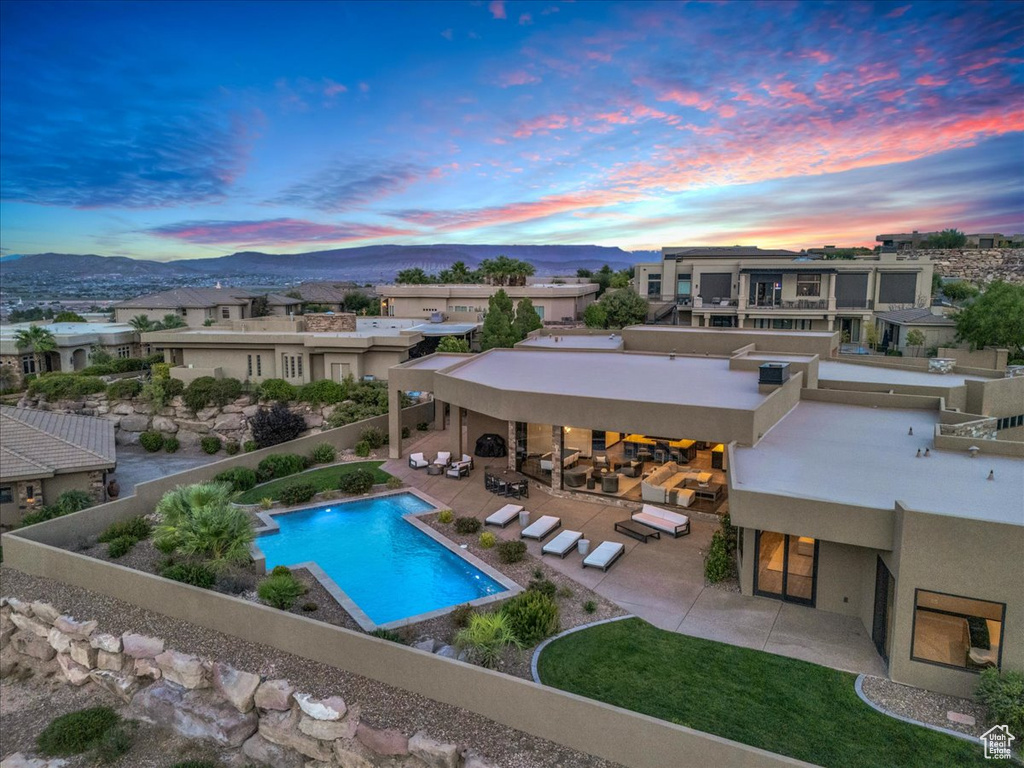 Pool at dusk featuring a patio and a mountain view