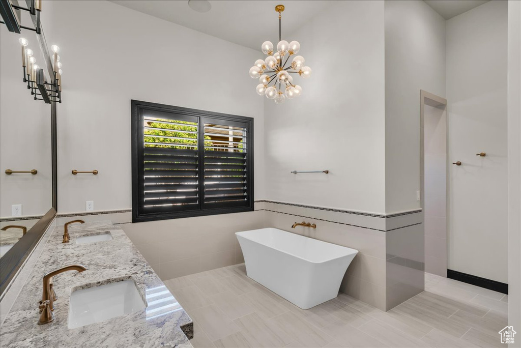 Bathroom featuring a bathing tub, a chandelier, and vanity