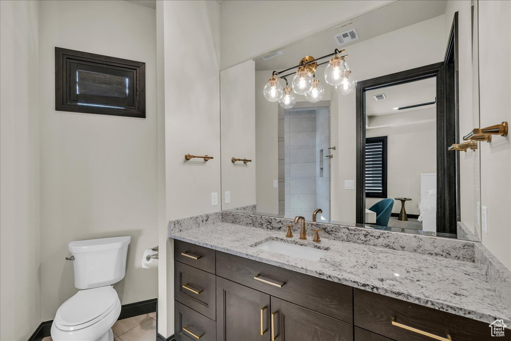 Bathroom featuring vanity, toilet, and tile patterned flooring