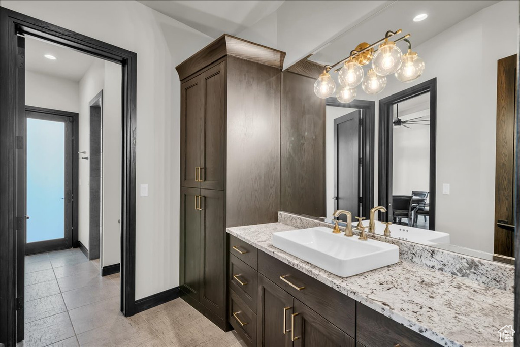 Bathroom with tile patterned floors, ceiling fan, and vanity