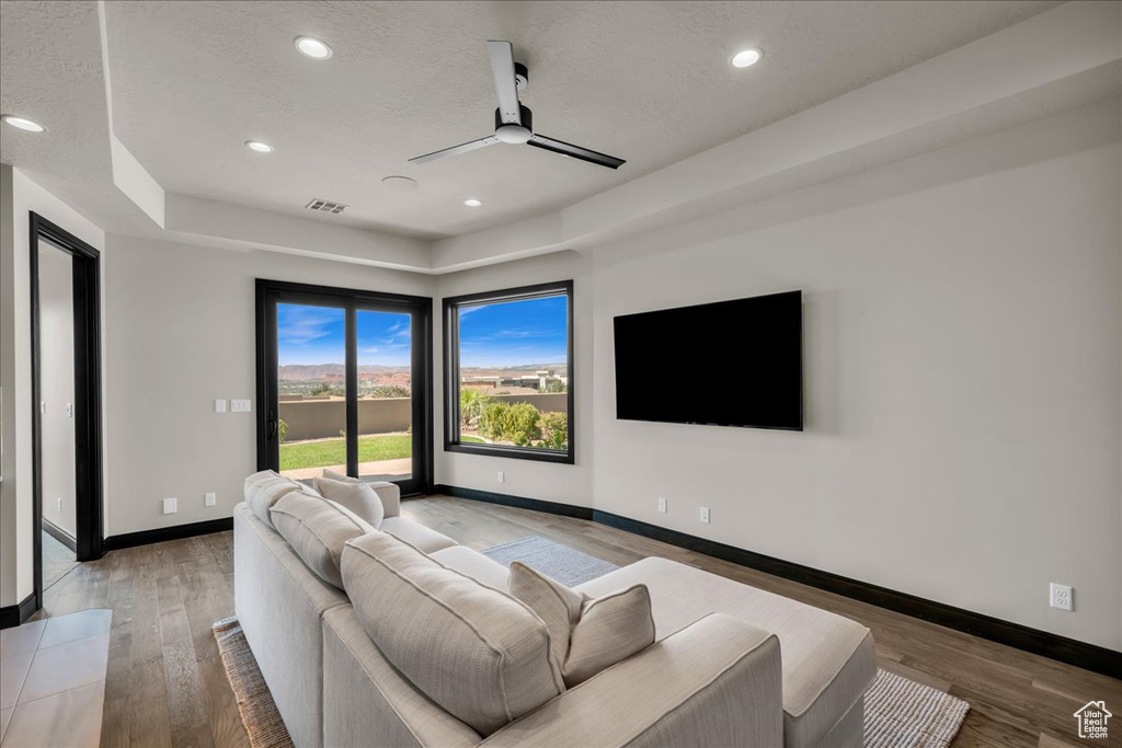 Living room featuring a textured ceiling, ceiling fan, and hardwood / wood-style flooring