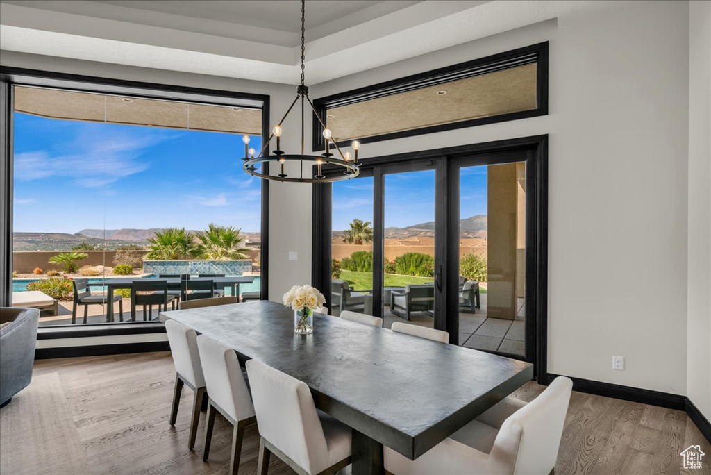 Dining space with a mountain view, hardwood / wood-style floors, and an inviting chandelier