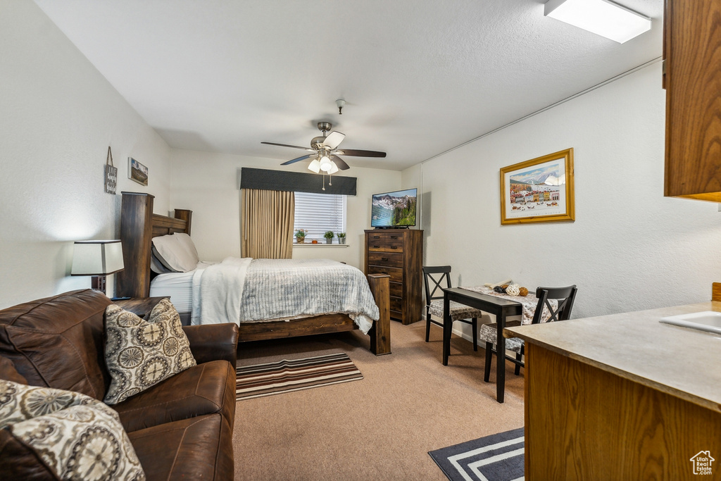 Bedroom featuring light colored carpet, ceiling fan, and a textured ceiling