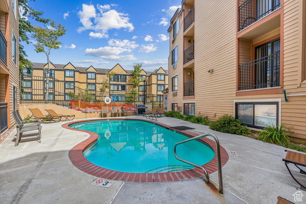 View of swimming pool featuring grilling area and a patio area