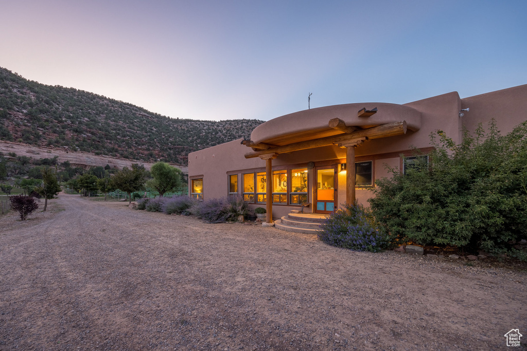 Back of property at dusk with a mountain view
