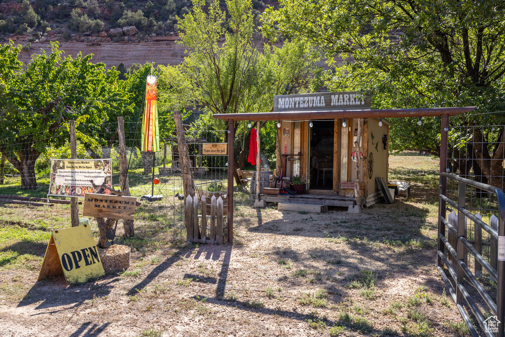 Exterior space featuring an outbuilding, a storage shed, and fence