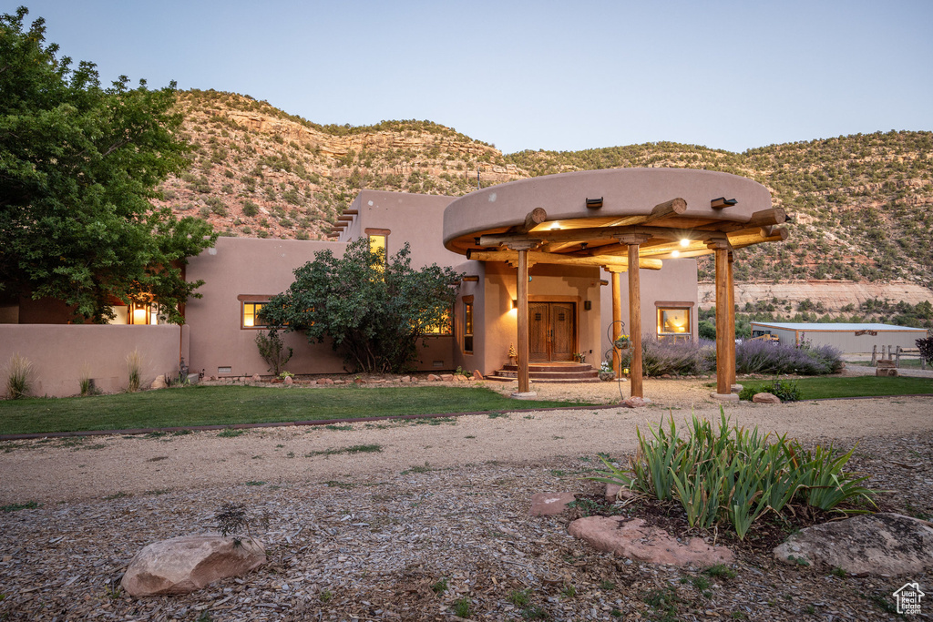 Pueblo revival-style home with a mountain view and stucco siding