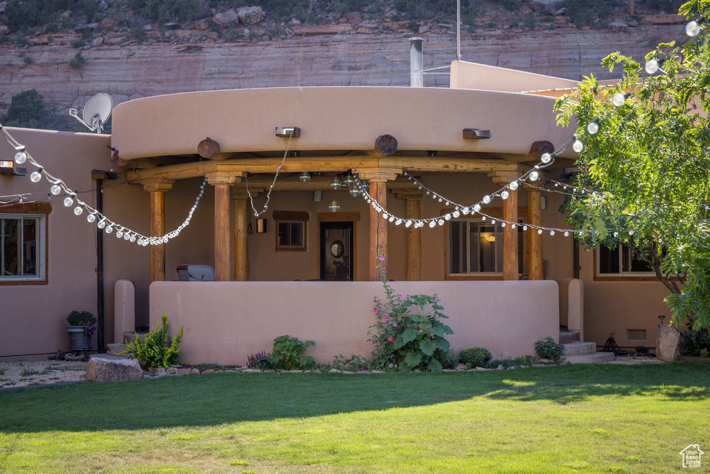 Pueblo-style home featuring a front lawn