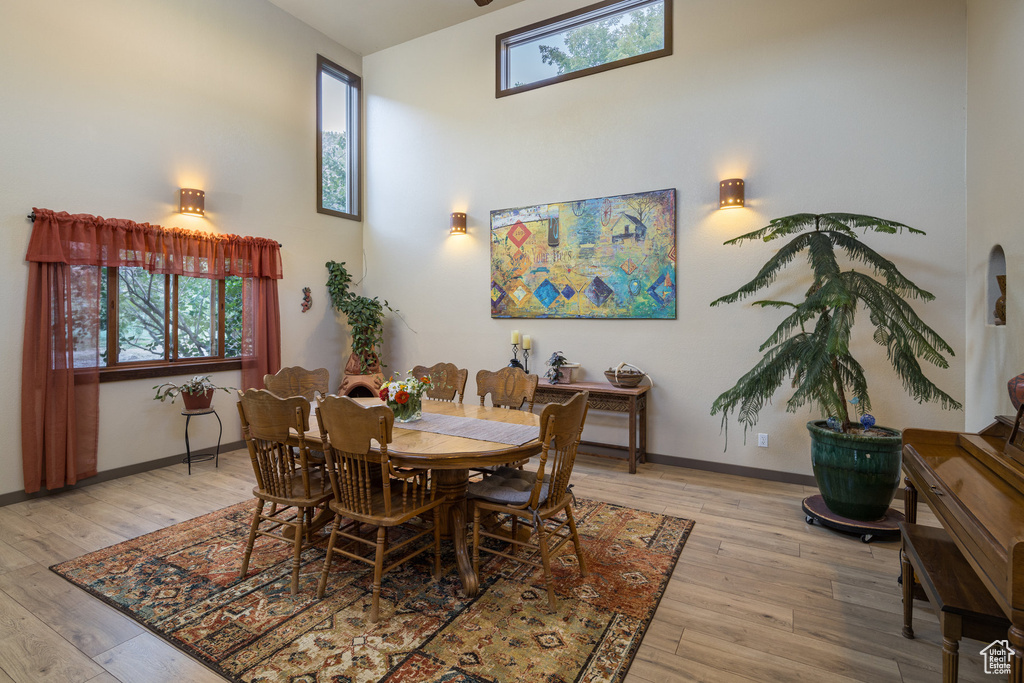 Dining area with baseboards, light wood-type flooring, and a healthy amount of sunlight