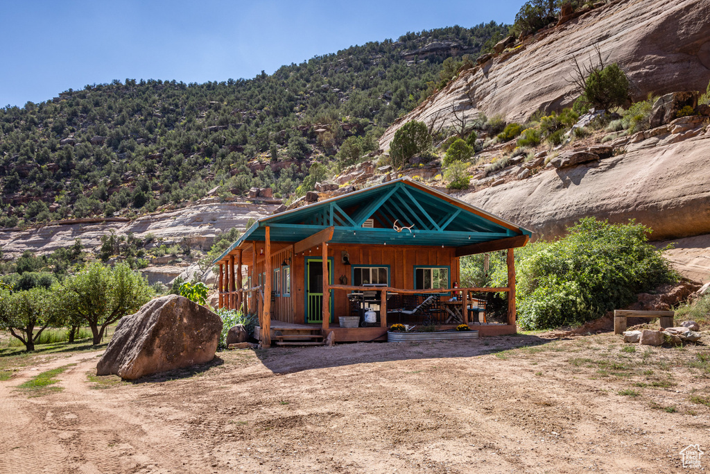 Rear view of house with a porch, a forest view, and a mountain view