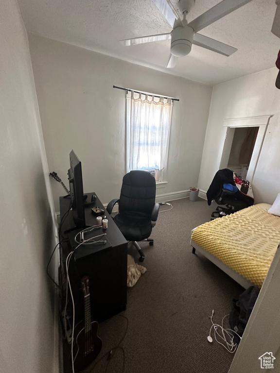 Bedroom featuring a textured ceiling, ceiling fan, and carpet