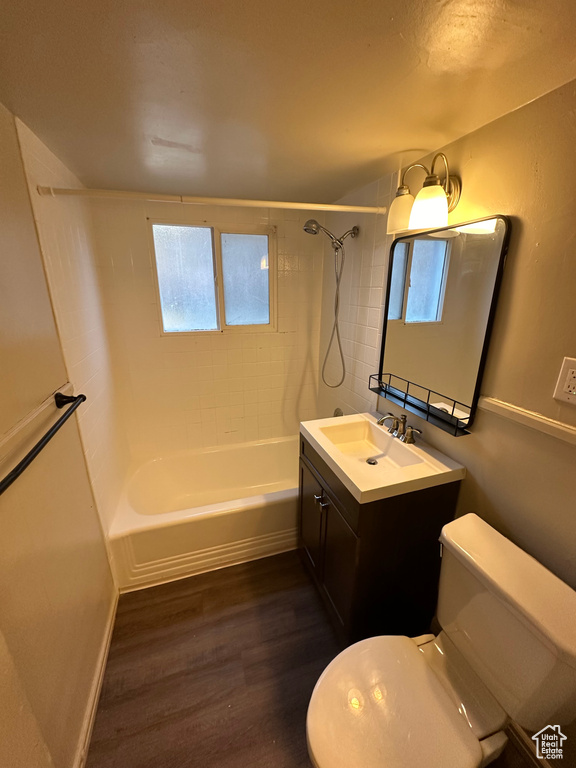 Full bathroom featuring hardwood / wood-style flooring, tiled shower / bath, toilet, and vanity