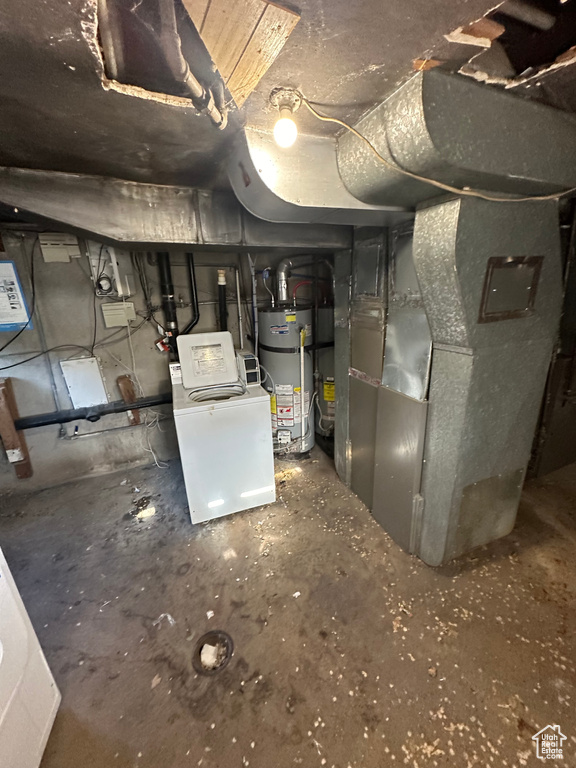 Utility room with strapped water heater, washer / clothes dryer, and heating unit