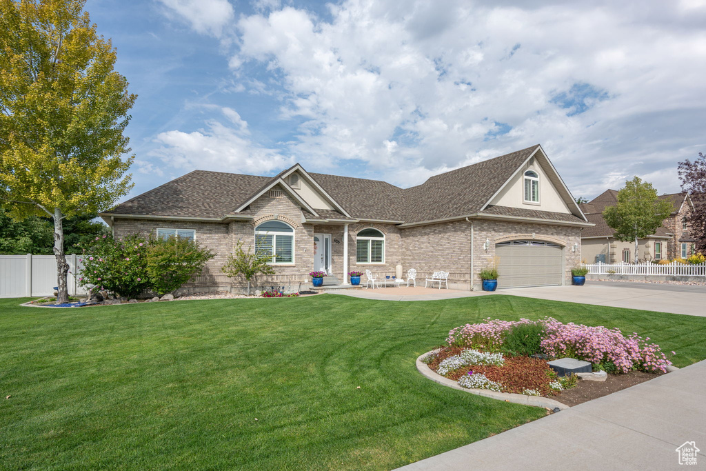 View of front of home featuring a front lawn and a garage