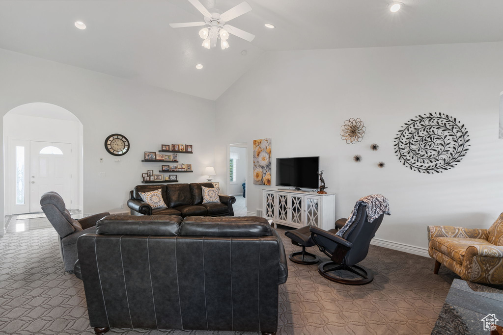 Carpeted living room featuring lofted ceiling and ceiling fan