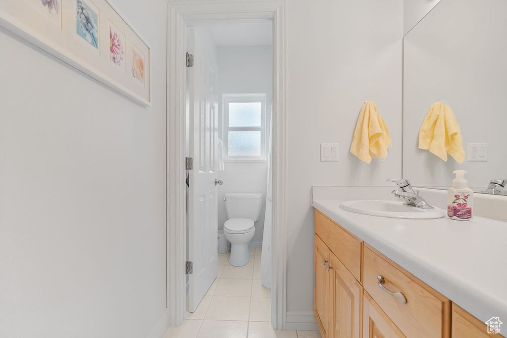 Bathroom with tile patterned floors, toilet, and vanity