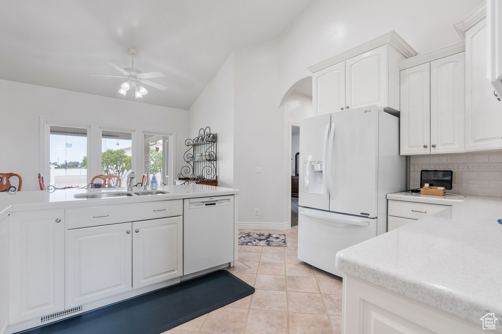 Kitchen featuring ceiling fan, sink, white appliances, and white cabinets