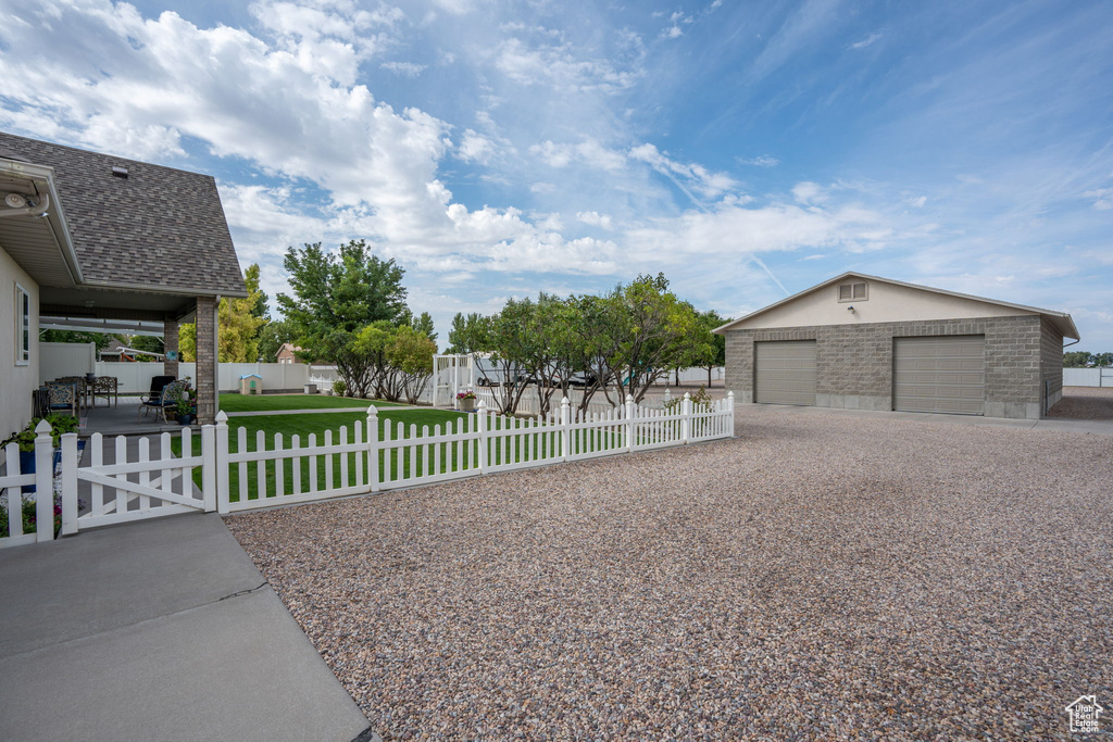 View of side of property with an outdoor structure, a garage, and a yard