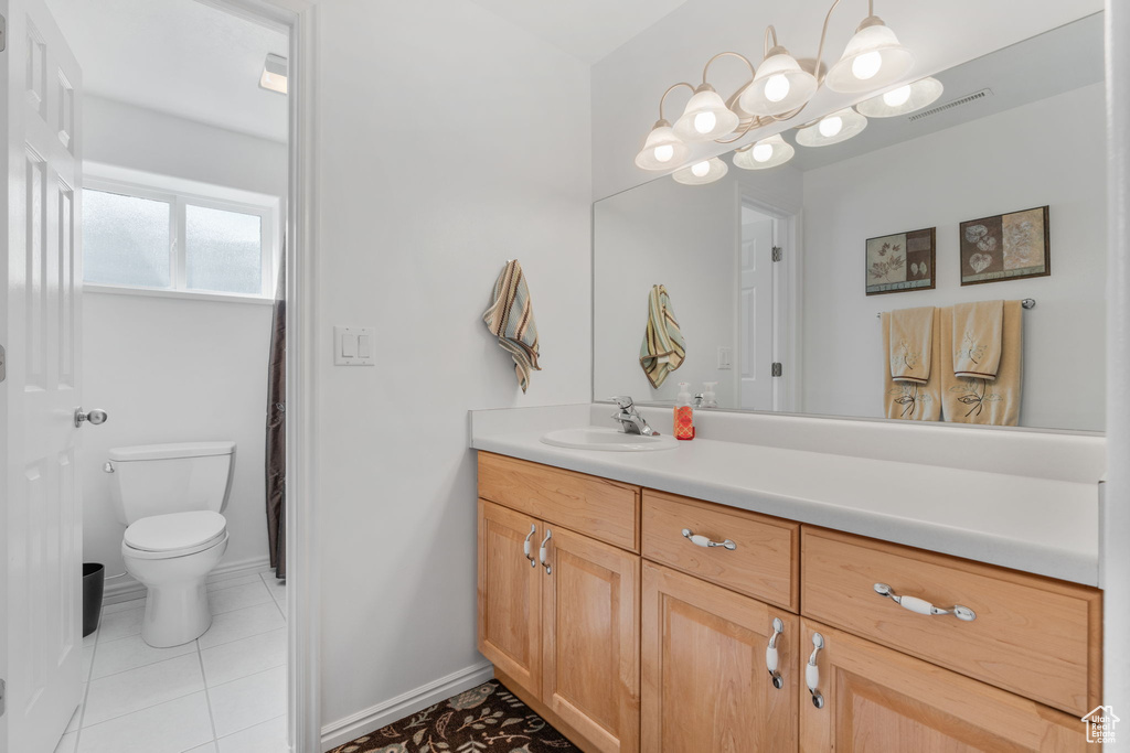 Bathroom featuring tile patterned flooring, toilet, and vanity