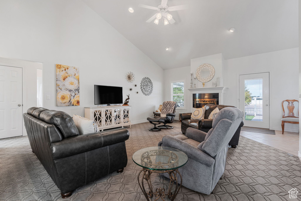 Living room with high vaulted ceiling, ceiling fan, and carpet floors