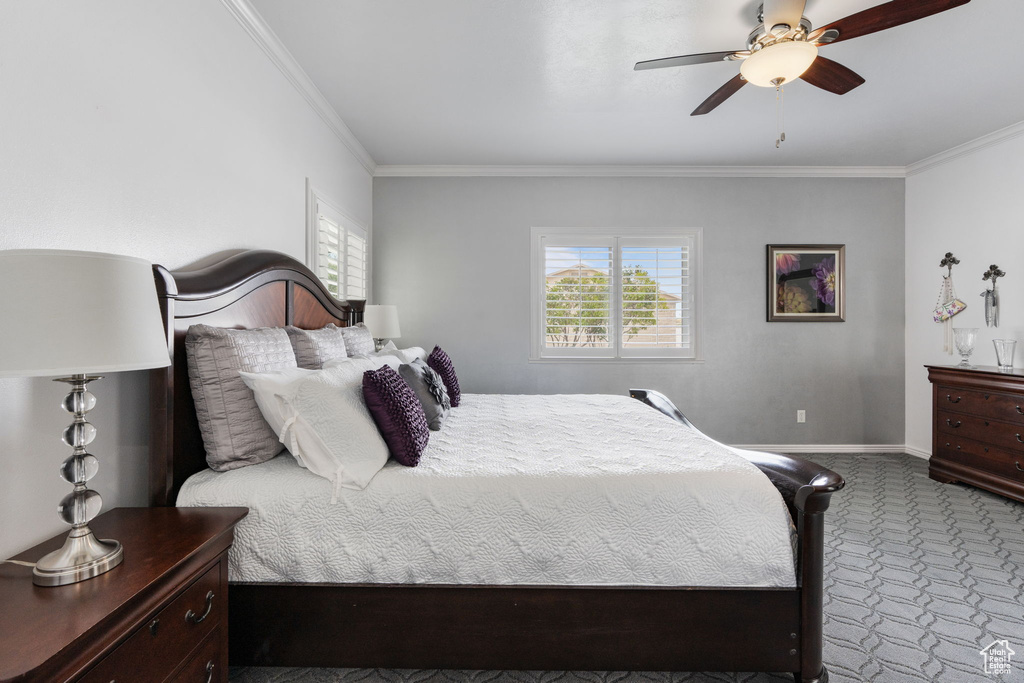 Carpeted bedroom with crown molding and ceiling fan