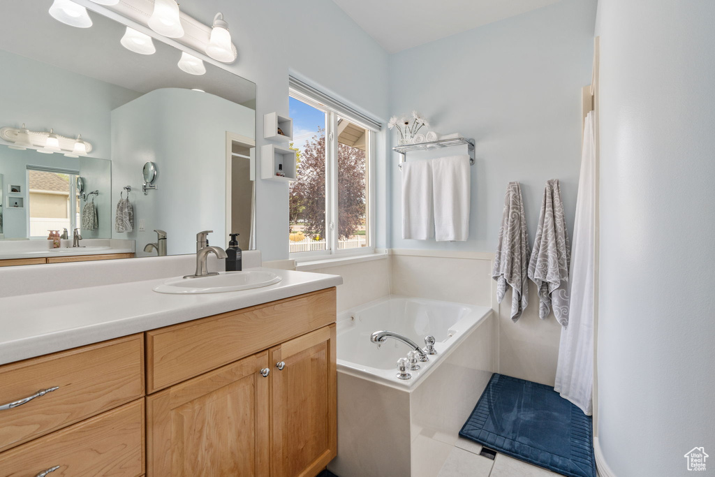 Bathroom featuring vanity, tile patterned floors, and a bathtub