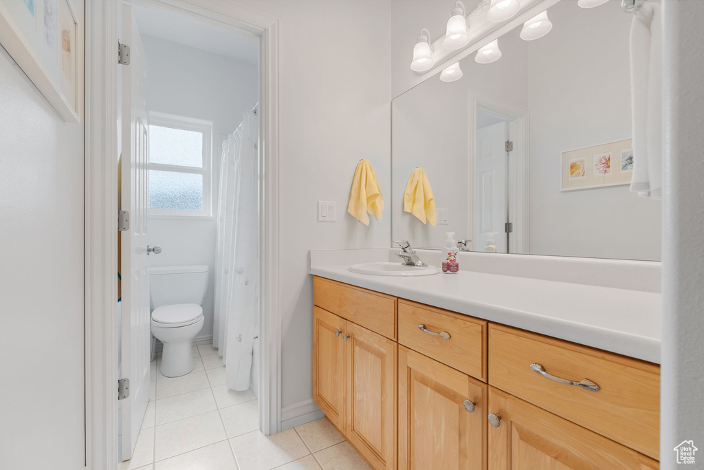 Bathroom featuring vanity, toilet, and tile patterned flooring