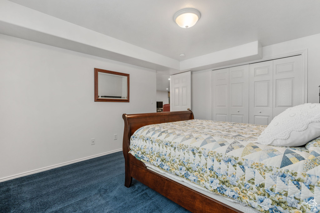 Bedroom with dark carpet and a closet