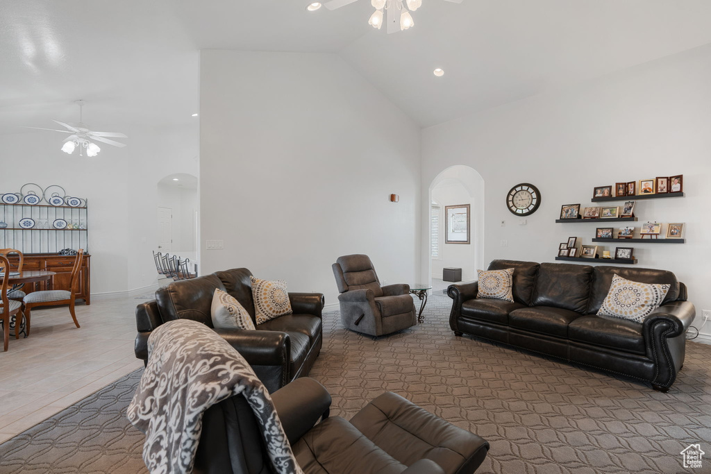 Living room with ceiling fan and high vaulted ceiling