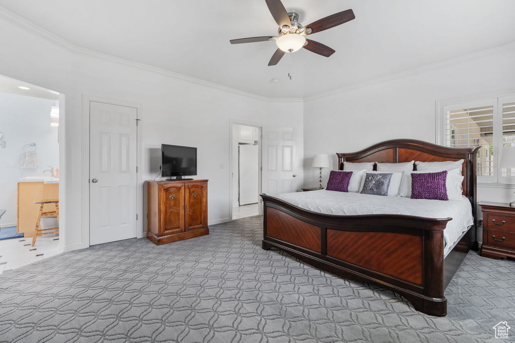 Carpeted bedroom with ornamental molding and ceiling fan