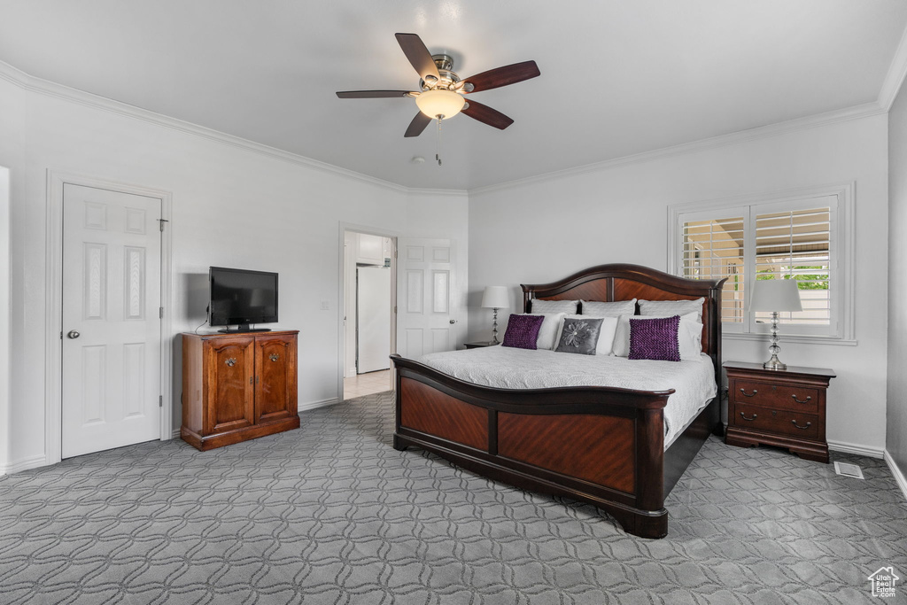 Carpeted bedroom featuring crown molding and ceiling fan