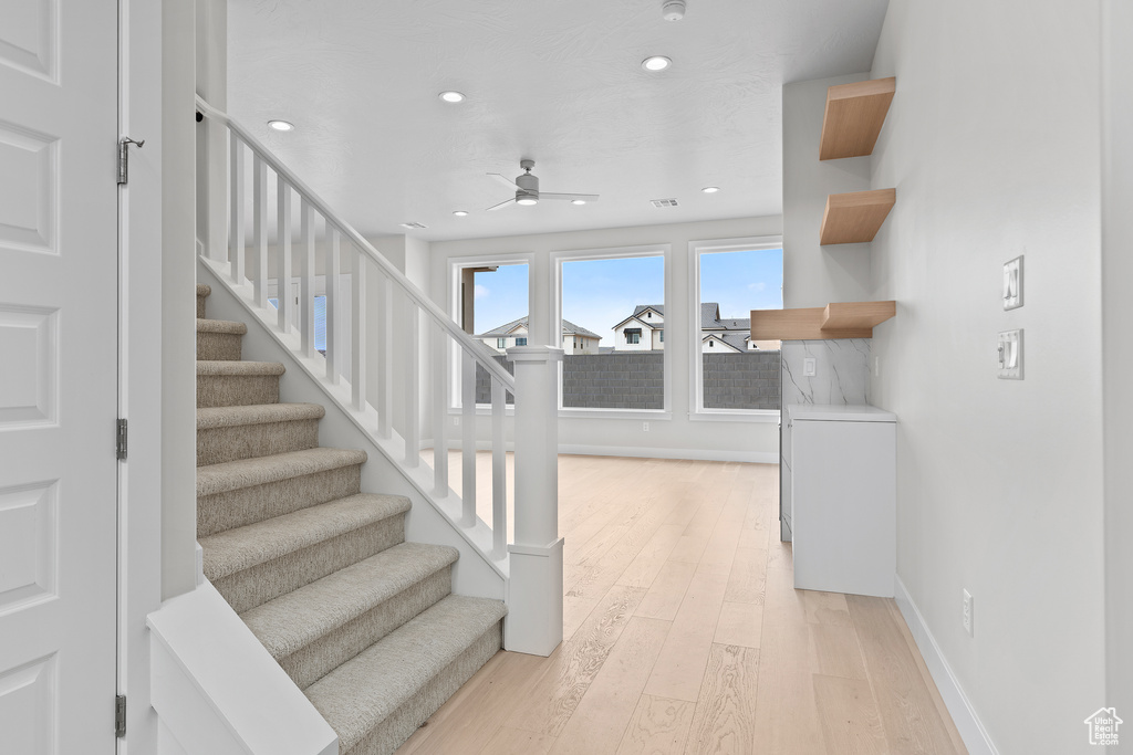 Stairs featuring recessed lighting, visible vents, a ceiling fan, wood finished floors, and baseboards