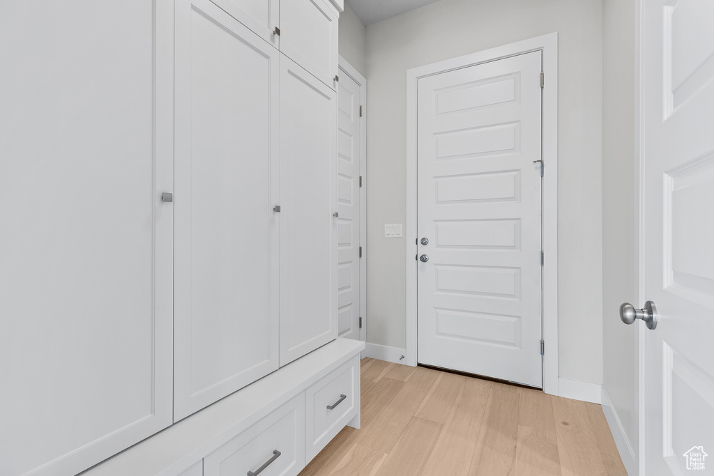 Mudroom with light wood-style flooring and baseboards