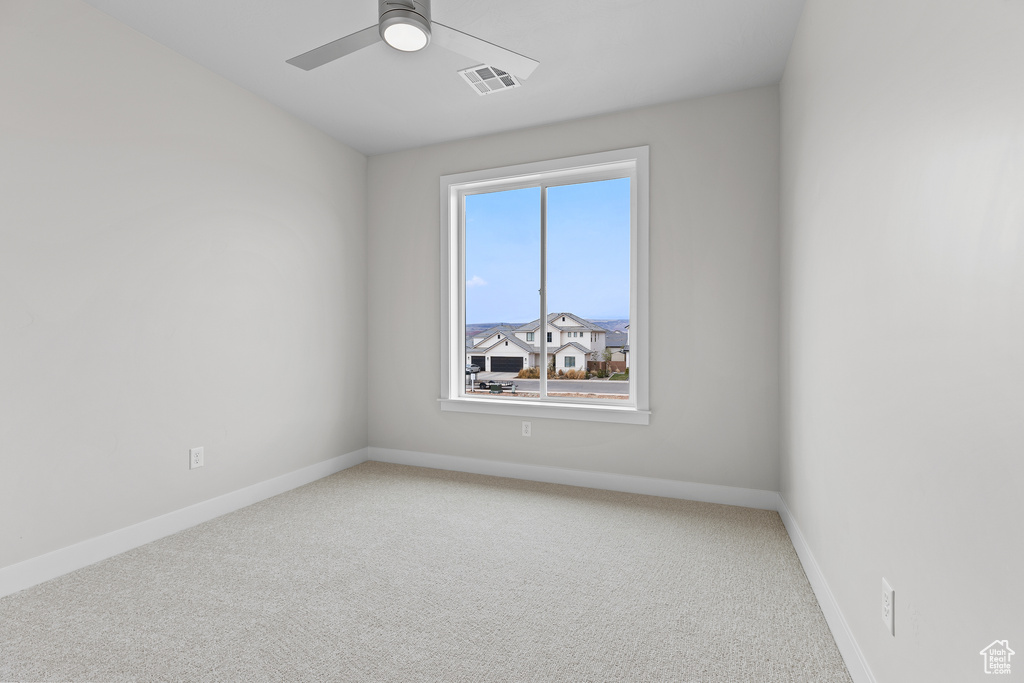 Unfurnished room featuring baseboards, visible vents, ceiling fan, and light colored carpet