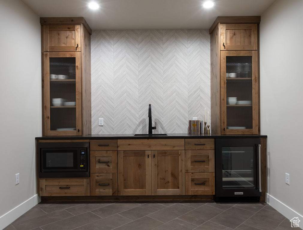 Bar with black microwave, wine cooler, sink, and dark tile patterned floors