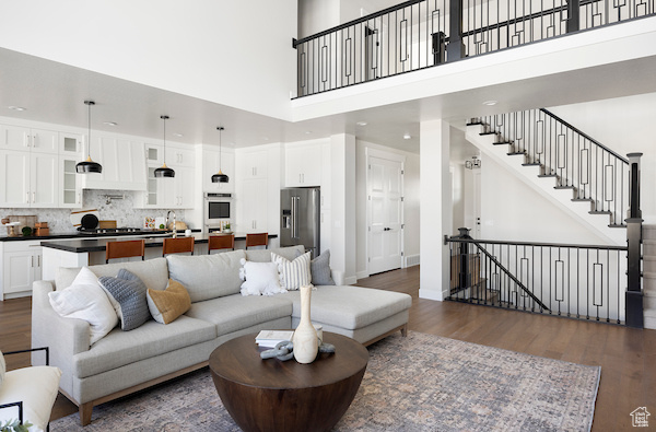 Living room featuring dark wood-type flooring and a high ceiling