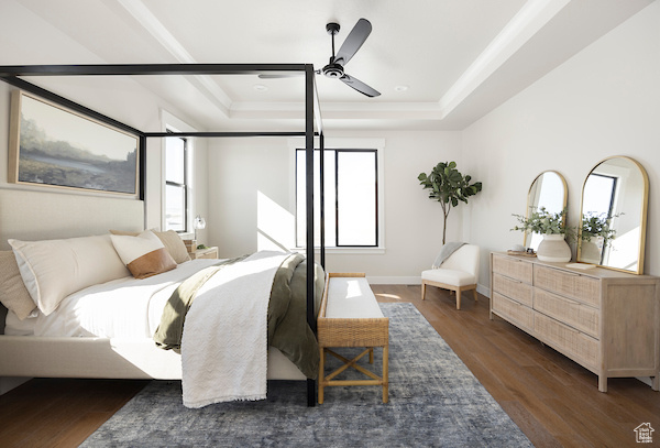 Bedroom with ceiling fan, dark hardwood / wood-style floors, and a raised ceiling