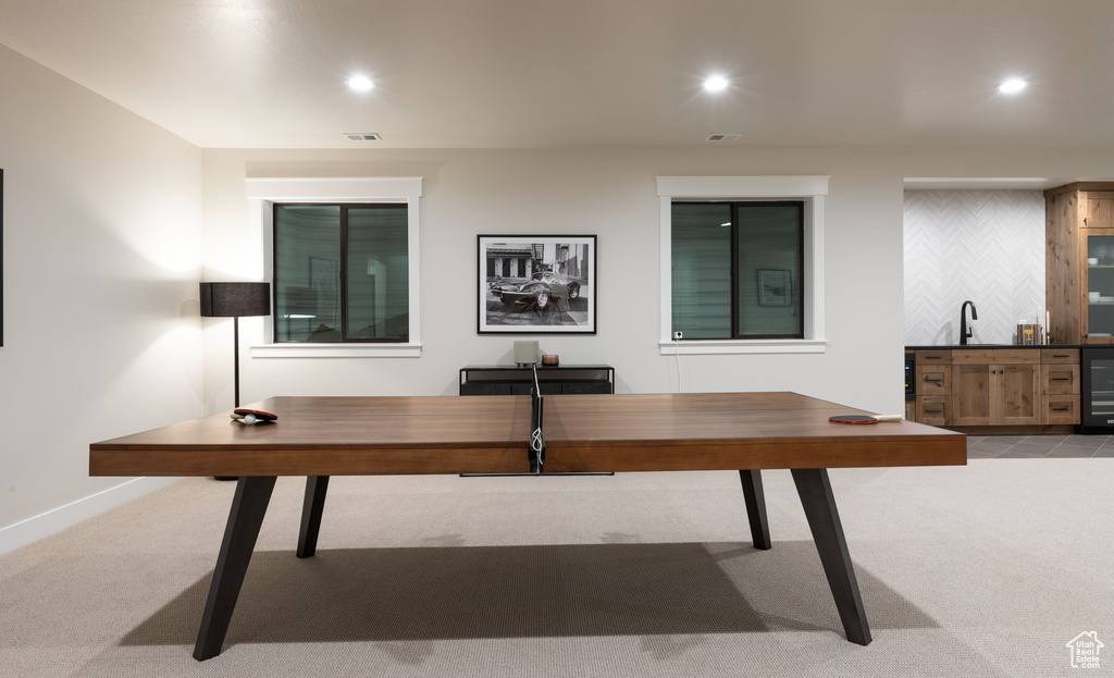 Home office with beverage cooler and light colored carpet