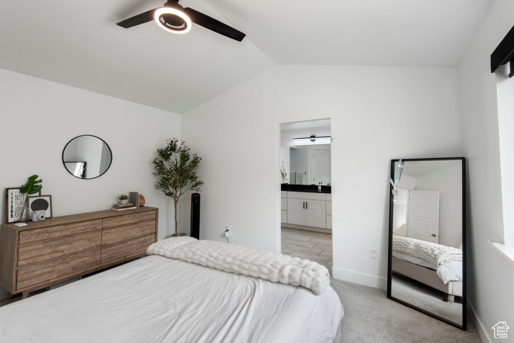 Carpeted bedroom with ceiling fan, ensuite bathroom, and vaulted ceiling