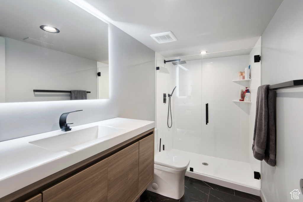 Bathroom featuring walk in shower, toilet, and vanity