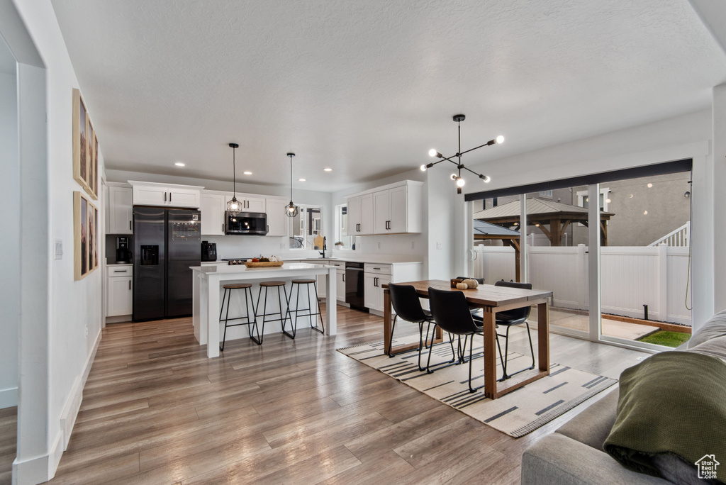 Dining space with light wood-type flooring and a notable chandelier