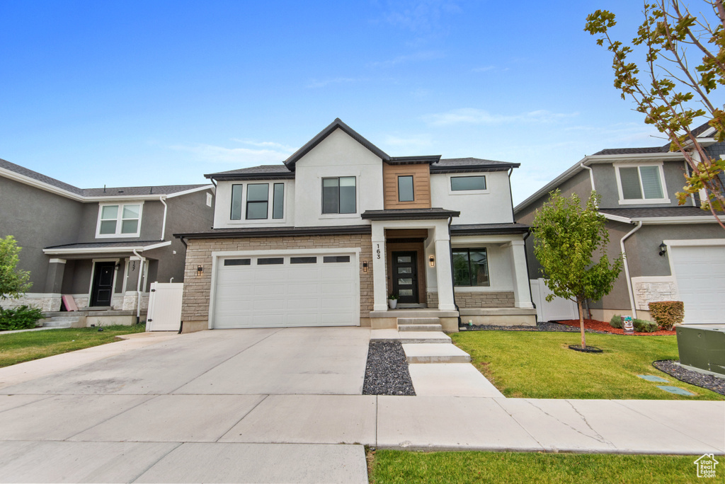 View of front of home with a garage and a front yard