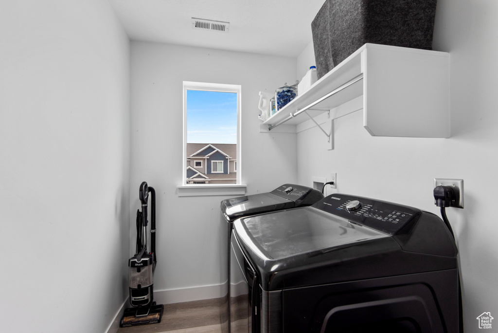 Washroom with washer and dryer and hardwood / wood-style flooring