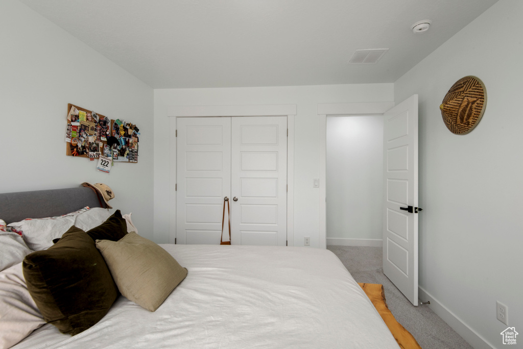 Carpeted bedroom featuring a closet