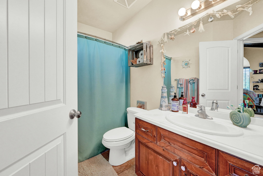 Bathroom with vanity, toilet, and tile patterned flooring